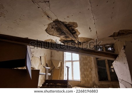 Abandoned place Residential house: Dark room with light window and collapsed ceiling and old junk.