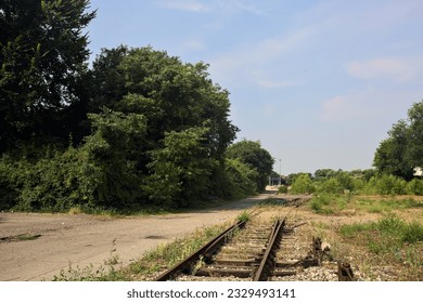 Abandoned  railroad tracks next to a building in an italian town in summer - Powered by Shutterstock