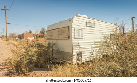 An Abandoned Retro Travel Trailer RV In An Overgrown Lot