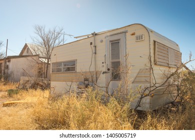 An Abandoned Retro Travel Trailer RV In An Overgrown Lot