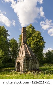 Abandoned Ruin Of Oven Chimney. Broken Furnace. Green Meadow Environment And Blue Sky Background