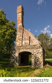 Abandoned Ruin Of Oven Chimney. Broken Furnace. Green Meadow Environment And Blue Sky Background