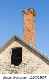 Abandoned Ruin Of Oven Chimney. Broken Furnace. Snowy Roof, Stork Slot And Blue Sky Background In The Winter