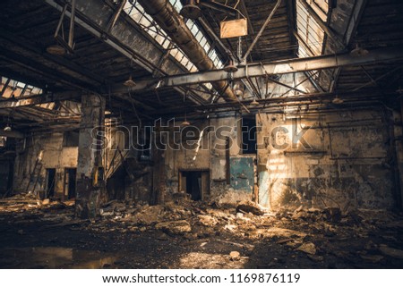 Abandoned ruined industrial warehouse or factory building inside, corridor view with perspective, ruins and demolition concept, toned