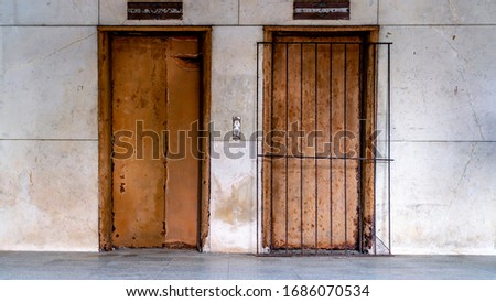 Abandoned and ruined residential building. Rusted doors of an out of service elevator.