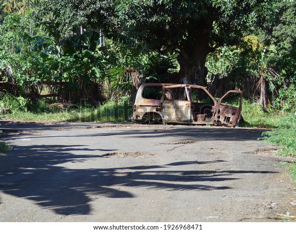 Abandoned rust damaged car in the jungle of\
Comoros island.