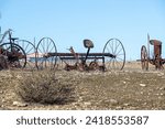 Abandoned, rusting vintage farm equipment in an open field