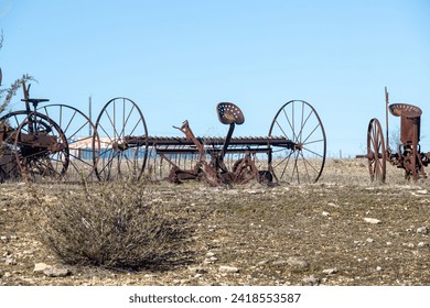 Abandoned, rusting vintage farm equipment in an open field - Powered by Shutterstock