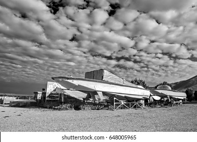 Abandoned Rusty Boats On A Dramatic Cloudy Sky Background. Sevan, Armenia. Black And White Photography