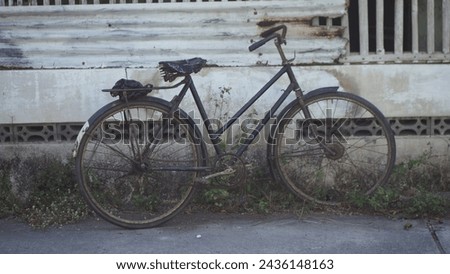 an abandoned rusty old bike on the side of the road