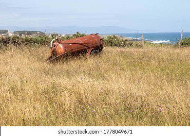 Abandoned Rusty Water Bower Or Muck Spreader In A Meadow In Galicia Spain