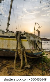 Abandoned Sailing Boat Or Yacht Laying On Beach In Kribi, Cameroon During Sunset, Africa