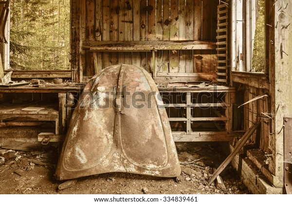 Abandoned shed\
with a rusted car hood in a\
forest