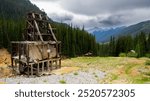 Colorado’s abandoned Silver Ledge Mine headframe sits with a view of the San Juan Mountains, between the towns of Ouray and Silverton, part of the Rocky Mountains, with trees and forests, summer 2024