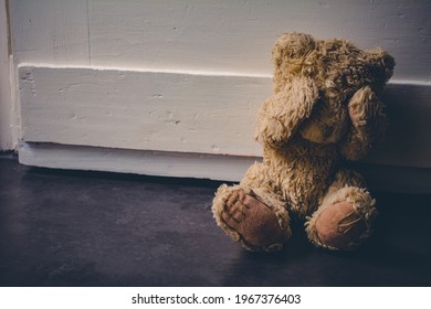 Abandoned Teddy Covering His Eyes, Sitting At A Door - Child Abuse Concept