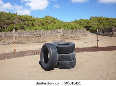 Abandoned tires on a sandy beach - Powered by Shutterstock