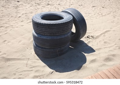 Abandoned tires on a sandy beach - Powered by Shutterstock