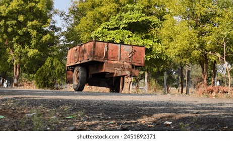 An abandoned tractor trailer sits by the roadside, its paint faded and rusted, with a dilapidated granary in the background.Rusty truck, abandoned farm, rural decay, forgotten road, vintage. - Powered by Shutterstock