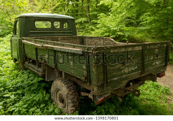 Abandoned\
truck in wild nature, surrounded with\
woods.