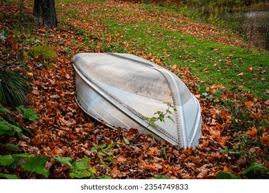 Abandoned upturned rowing boat surrounded by fall leaves, in Vermont USA