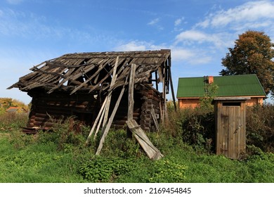 Abandoned, useless wooden house or barn. Falling apart structure. Rickety wooden construction.