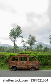 Abandoned van parked in side of hill road in a foggy bright day