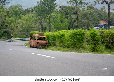 Abandoned van parked in side of hill road in a foggy bright day