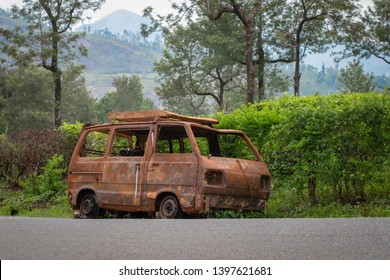 Abandoned van parked in side of hill road in a foggy bright day