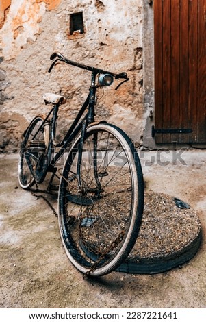 Abandoned vintage black bicycle at street of old town of Lovran in Croatia, selective focus