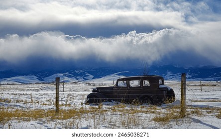 Abandoned vintage car is left to corrode in the scenic Montana countryside. Beautiful shot of a classic American car weathering the elements in the picturesque prairie. Classic car forgotten in nature - Powered by Shutterstock