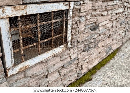 Abandoned warehouse window. Rusty grate window. Safety security protection. Light brick wall with metal grate window cover. Basement background