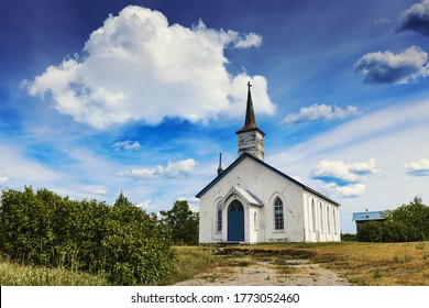 An abandoned white christian church in rural Ontario Canada with blue skies and green grass landscape. - Powered by Shutterstock