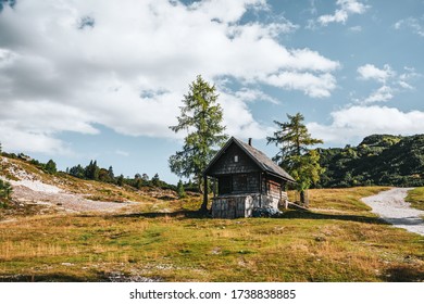 Abandoned wooden house in mountains, hiking trail. Sunny day on Vogel mountain in Slovenia.