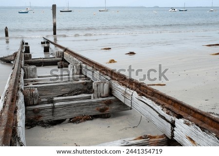 Abandoned wooden slipway with rusted iron glides on the beach by which ships or boats can be moved to and from the water