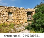 An abanoned rustic house made of blocks of reddish yellow limestone in the Eastern Mediterranean region