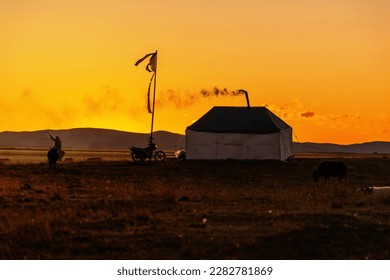Aba,Sichuan,China-October 14, 2019: A nomadic tent smokes under a golden dusk on the Zoige steppe. - Shutterstock ID 2282781869