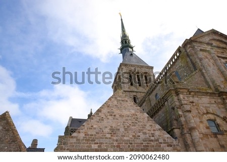 Abbey of Mont-Saint-Michel founded in the 8th century. Tourism on the Normandy coast in France, Unesco world heritage. High walls and bell tower surmounted by the golden statue of Archangel Michael