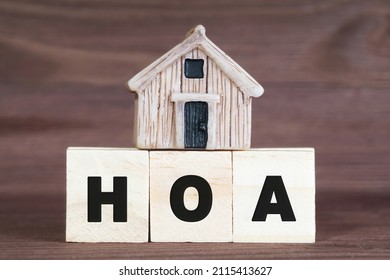 Abbreviation HOA made from wooden letter blocks with a miniature house on top. Homeowner association concept.