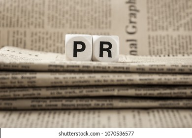 Abbreviation PR on newspapers background