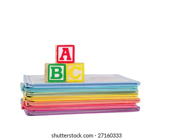 ABC Blocks Arranged On A Stack Of Rainbow Colored Children's Books.  Isolated On White.