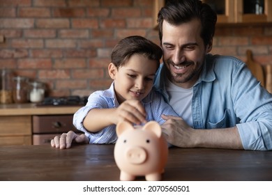 ABC Of Finance. Smiling Father Support Junior School Age Son In Wish To Save Pin Money Teach Rational Economy Wise Budget Planning. Caring Dad Hug Preteen Child Boy Putting Pocket Change To Piggybank