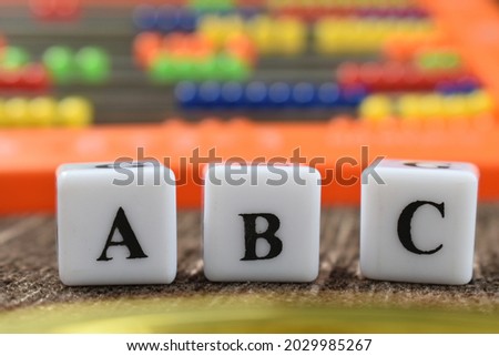 ABC in focus with abacus in background.