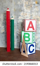 ABC Letters Alphabet On Wooden Cube Blocks In Pillar Form. Interior Of Elementary School. Large Pencils And Wooden Cubes Abc On Classroom. Teachers Day. Back To School. Kindergarten. 
