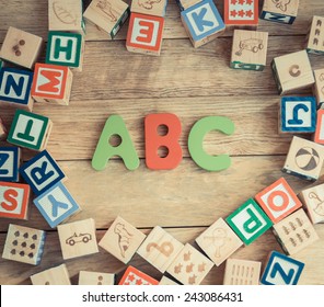 ABC word in wooden block alphabet lay on wooden floor in circle shape