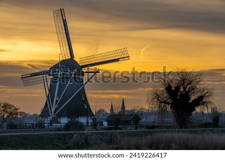 Abcoude, The Netherlands. Typical dutch landscape with traditional windmill by sunset