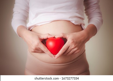 Abdomen of pregnant woman and red heart on white background.love and family insurance concept, world heart day

 - Powered by Shutterstock