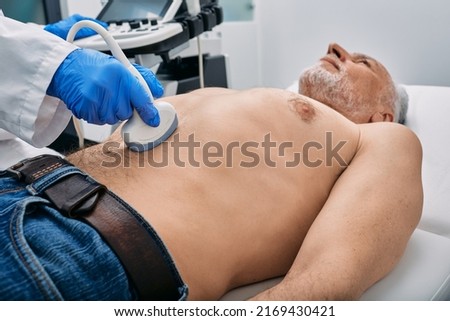 Abdominal ultrasound with ultrasound machine for male patient, close-up