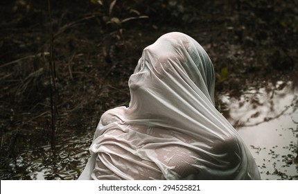 The abduction and Halloween theme: wrapped in a wet cloth person lying in the mud