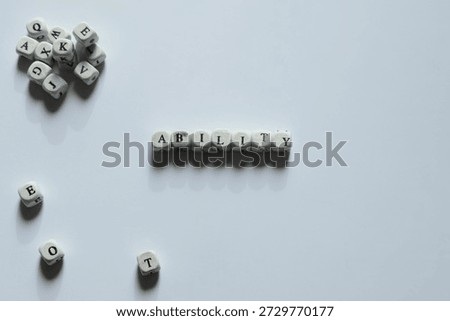 Ability spelled using letter blocks symbolizing competence, skills, and performance in a minimalist flat lay composition.