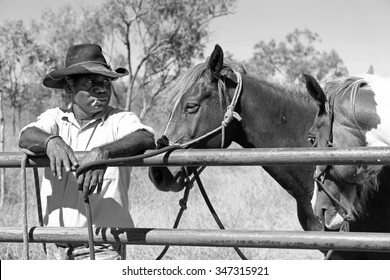 Aboriginal Cattleman Or Stockman Resting With Horses Having A Cigarette In Outback Australia Between Mustering Cattle